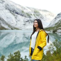 girl-tourist-in-yellow-jacket-posing-on-the-lake-in-norway-active-woman-relaxing-in-the-norway-.jpg