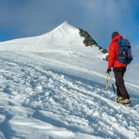 mountaineer-climbs-a-snowy-peak-in-swiss-alps-zermatt-switzerland-.jpg